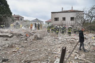Rescuers search for victims in the debris of a destroyed house following a Russian rocket strike on the outskirts of Lviv